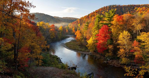 The Cuyahoga River flowing through forested hills in Cuyahoga Valley National Park, Ohio, on a clear autumn morning