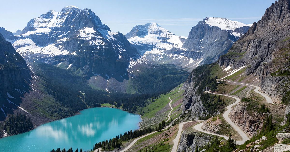 Going-to-the-Sun Road winding through Glacier National Park's alpine terrain with snow-capped peaks and turquoise lake below