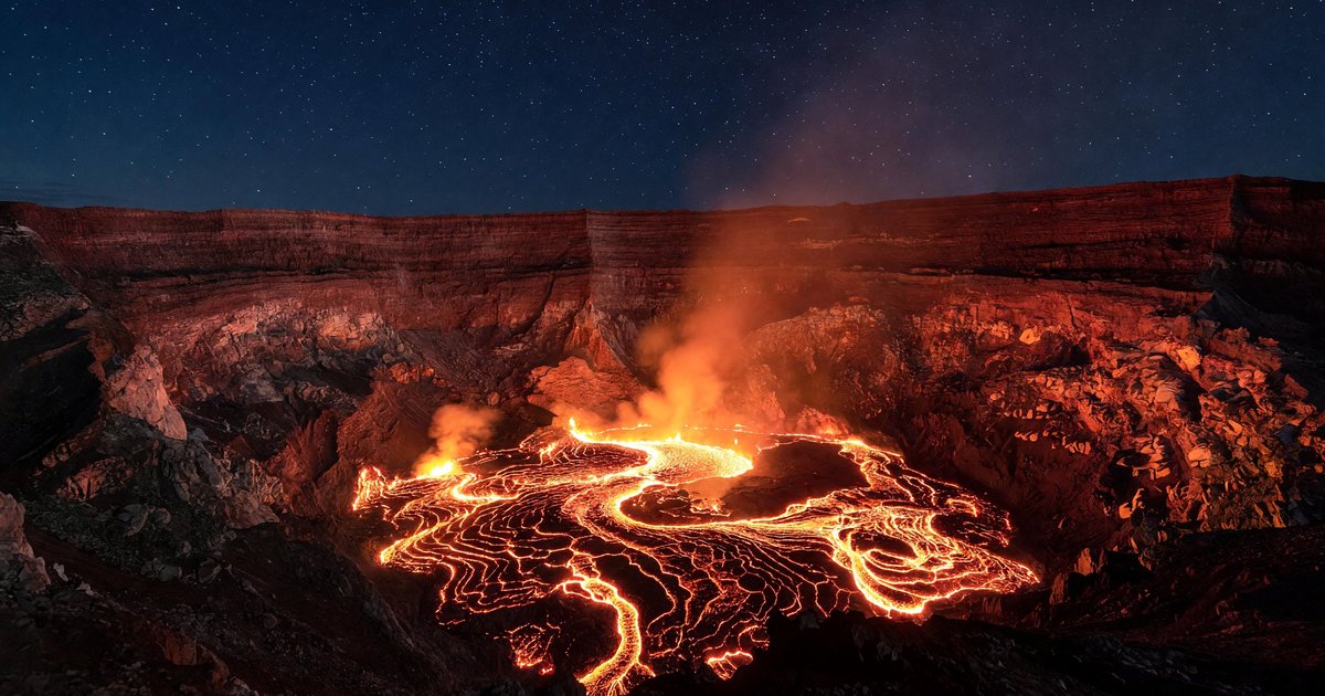 Glowing lava lake inside Halemaʻumaʻu Crater at night, illuminating the caldera walls of Kīlauea in Hawaii Volcanoes National Park