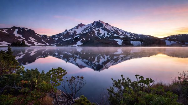 Lassen Peak volcano reflected in Manzanita Lake at dawn, California